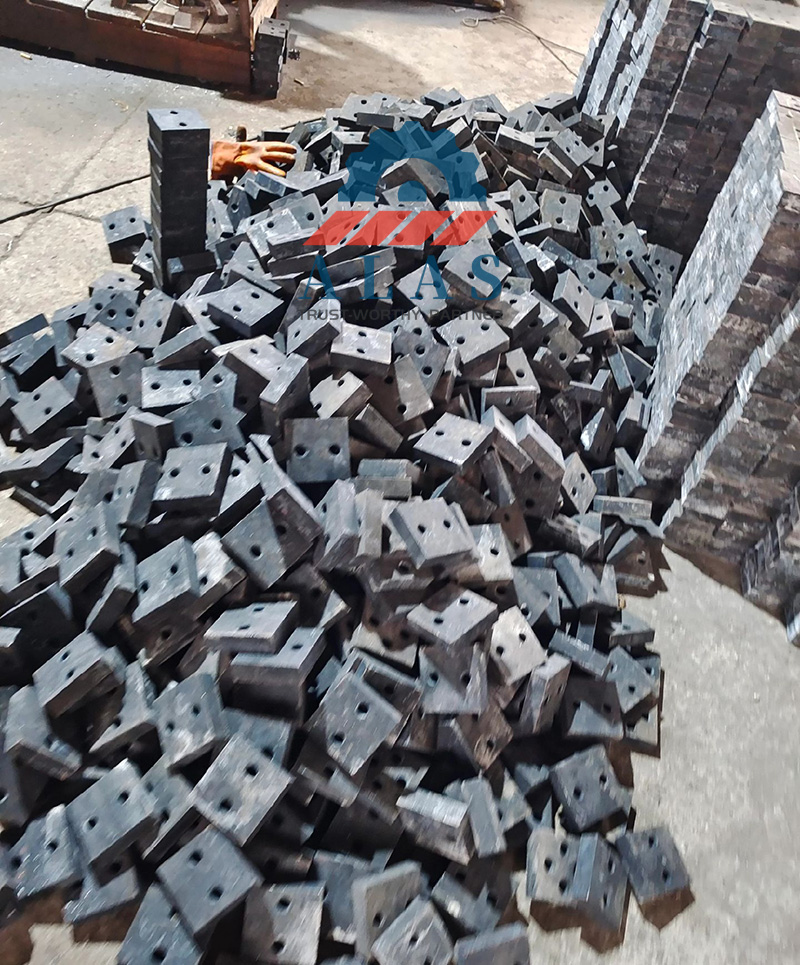 Massive Industrial Rebar Cutter Blades Bulk Inventory A large pile of bulk industrial rebar cutter blades and heavy duty steel shearing knives stacked on a factory floor ready for wholesale distribution