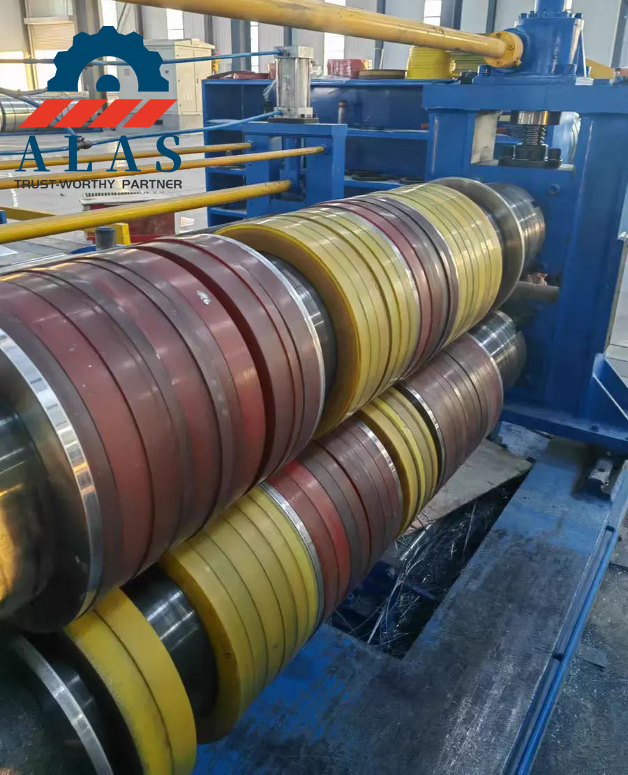 ALAS Rotary Slitter Knives and Spacers Machine Setup Industrial metal coil slitting machine line showing precision slitter knives, steel spacers, and rubber stripper rings assembly on arbors