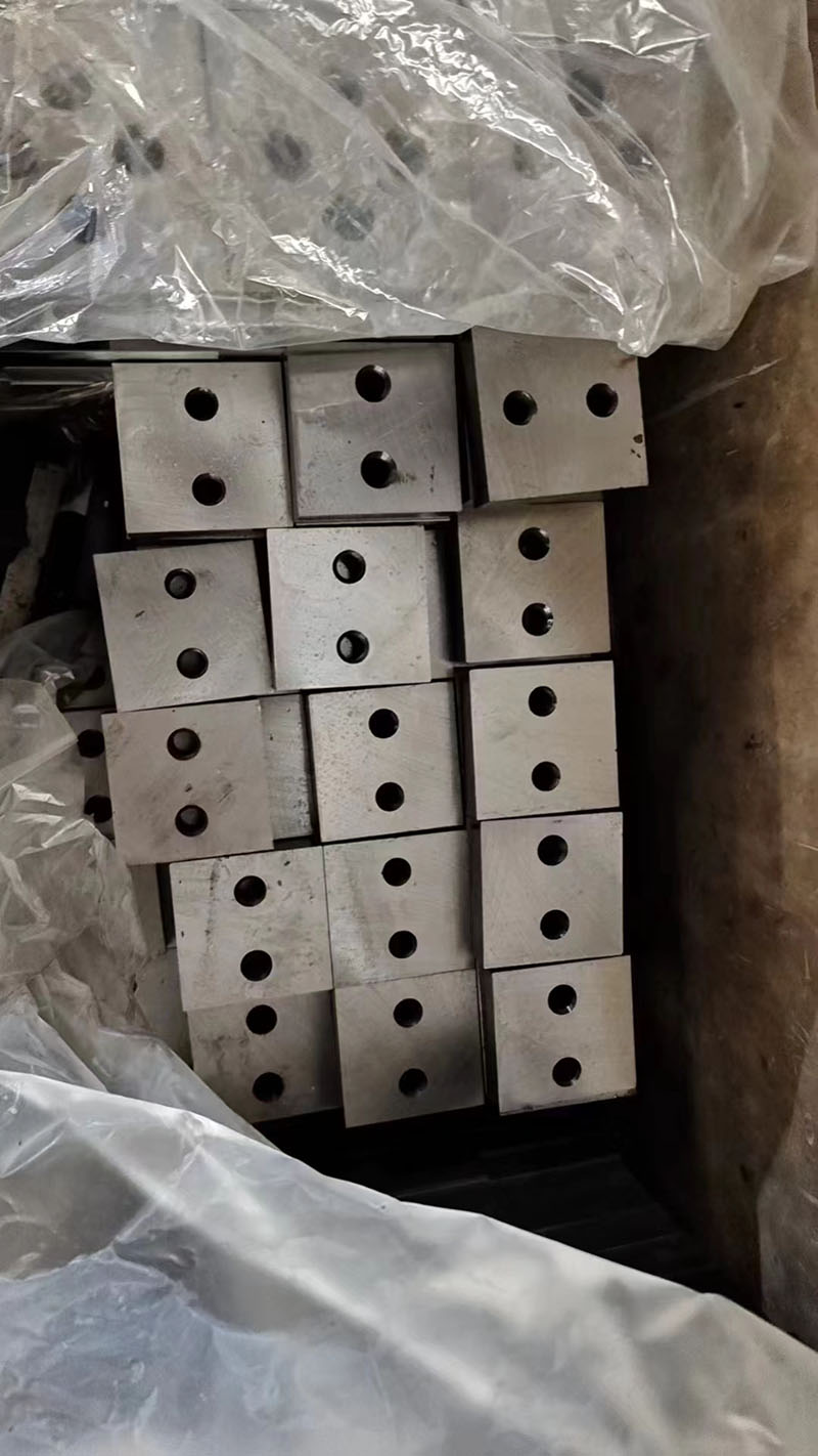 Close-up of square rebar shear blades showing 4 cutting edges and central mounting hole