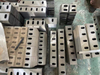 Bulk stock of industrial plastic crusher blades and rotor stator knives stacked in a manufacturing factory