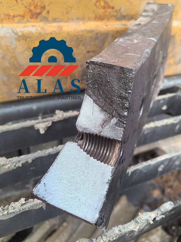 Catastrophic brittle fracture failure of a heavy scrap metal shear blade snapping directly across the threaded bolt hole section