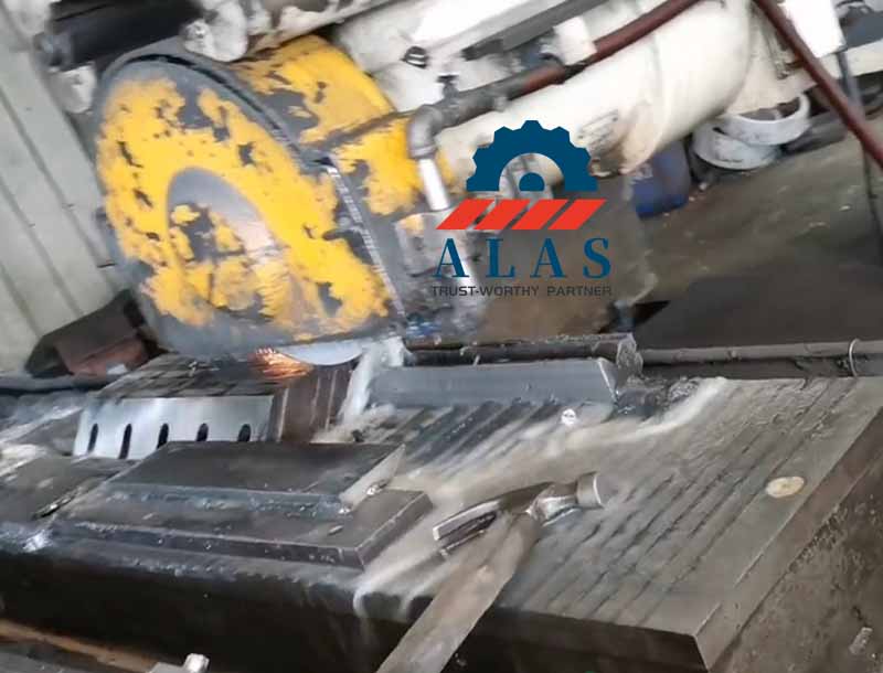 Industrial surface grinding machine utilizing continuous flood emulsion coolant to precision-grind the cutting rake face of a flat granulator blade.