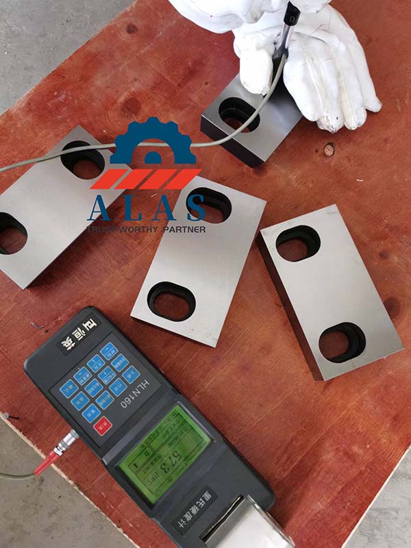 Quality control inspector verifying shear blade through-hardness registering 57.3 HRC on a digital tester