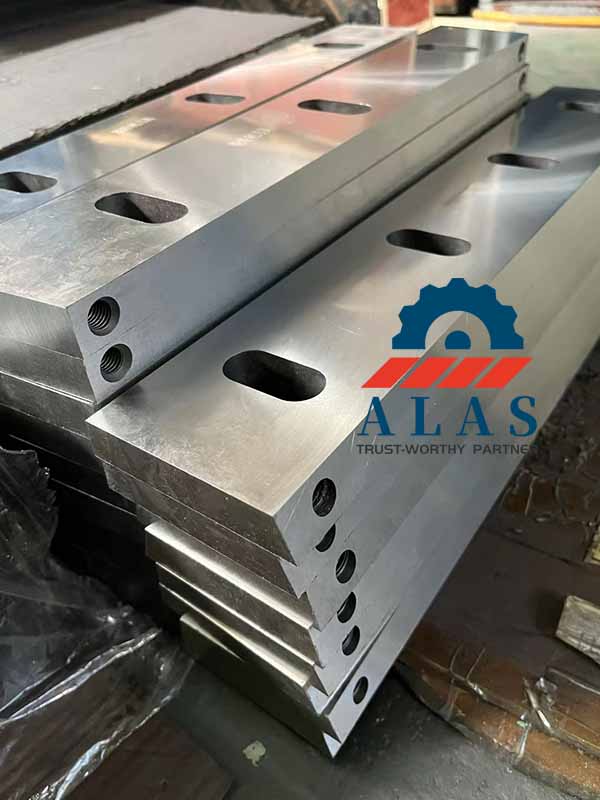 Close-up view of precision-ground D2 tool steel granulator knives featuring standardized elongated countersunk slots for Herbold machinery.