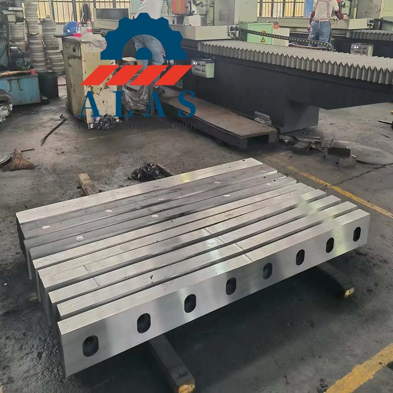 Batches of finished thick plate shearing machine knives stacked in the manufacturing facility.