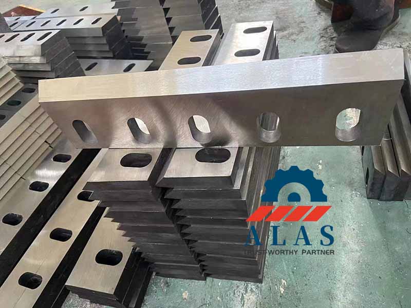 High-angle view of custom cold-work alloy steel granulator fly blades machined with uniform thickness uniformity and sharp single-bevel profiles.