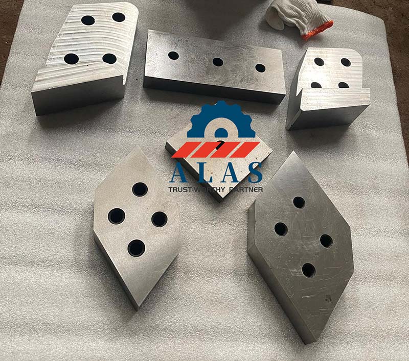 Symmetrical 4-edge indexable shear knives and guide blades on a factory workbench ready for shipment