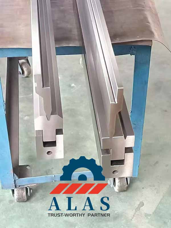 Two complete custom acute punch and die tooling sets assembled and resting on a workshop cart after high-frequency surface tempering.