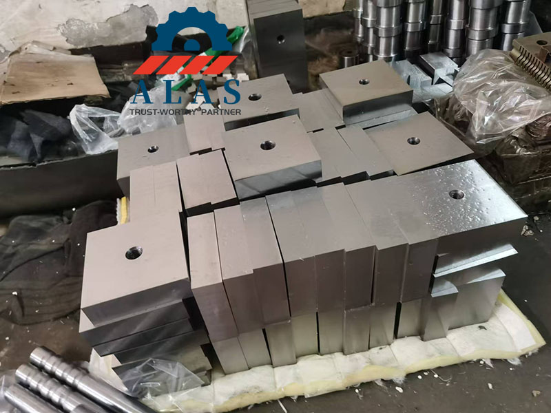 Bulk manufacturing of Cr12MoV and H13 steel rebar cutter blades stacked in a factory workshop.