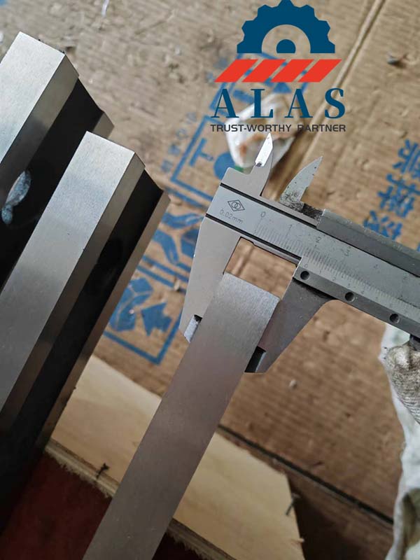 Machinist measuring the thickness tolerance of a cold-rolled fabrication straight knife with a caliper.