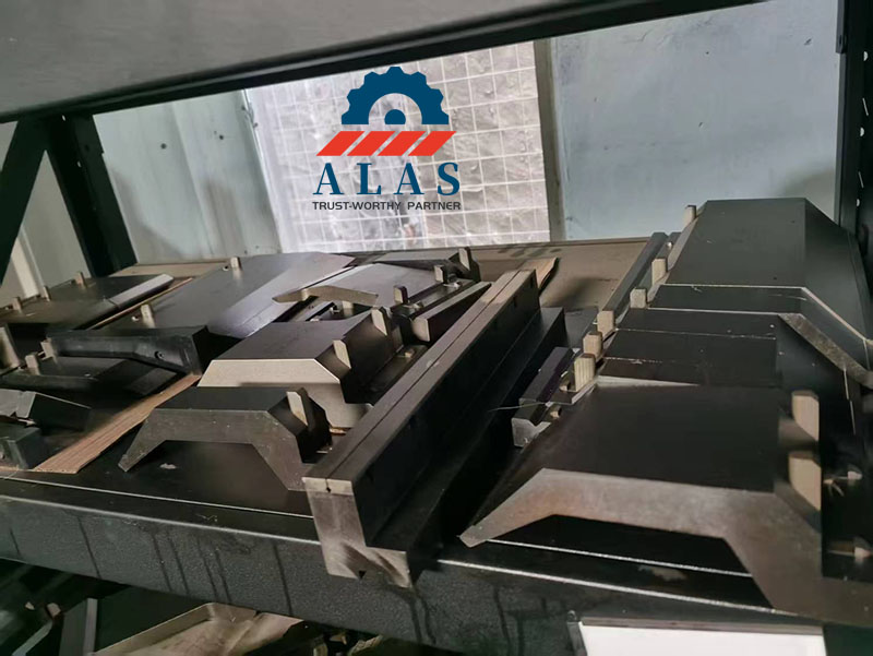 Custom black oxide coated gooseneck press brake punches stacked on factory stock shelves