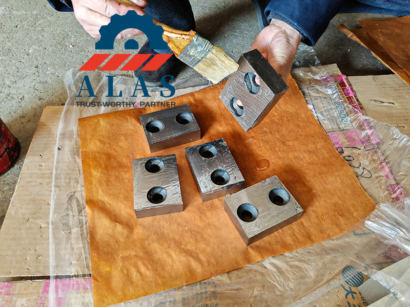 Applying anti-rust oil to rebar cutting machine blades during routine industrial maintenance