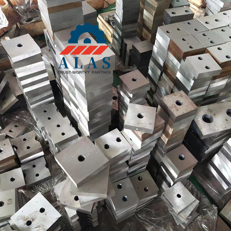 Bulk stock of heavy duty bar cutter blades including square, rectangular, and custom shaped H13 alloy steel rebar shearing knives in a manufacturing factory