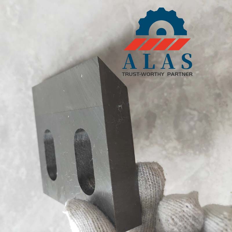 A factory worker holding a precision-engineered HSS inlaid granulator knife with critical tolerances