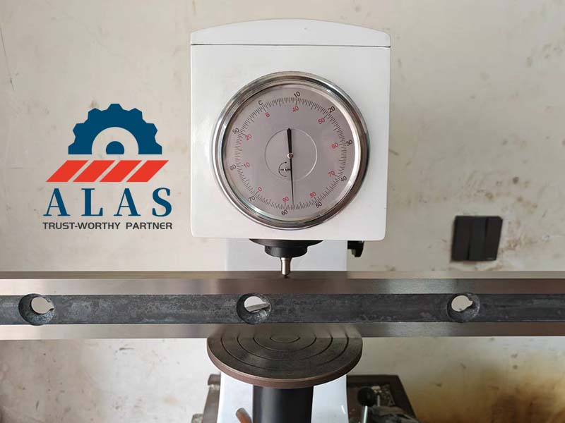 Quality control station conducting a Rockwell C scale verification on a thin metal cutter edge