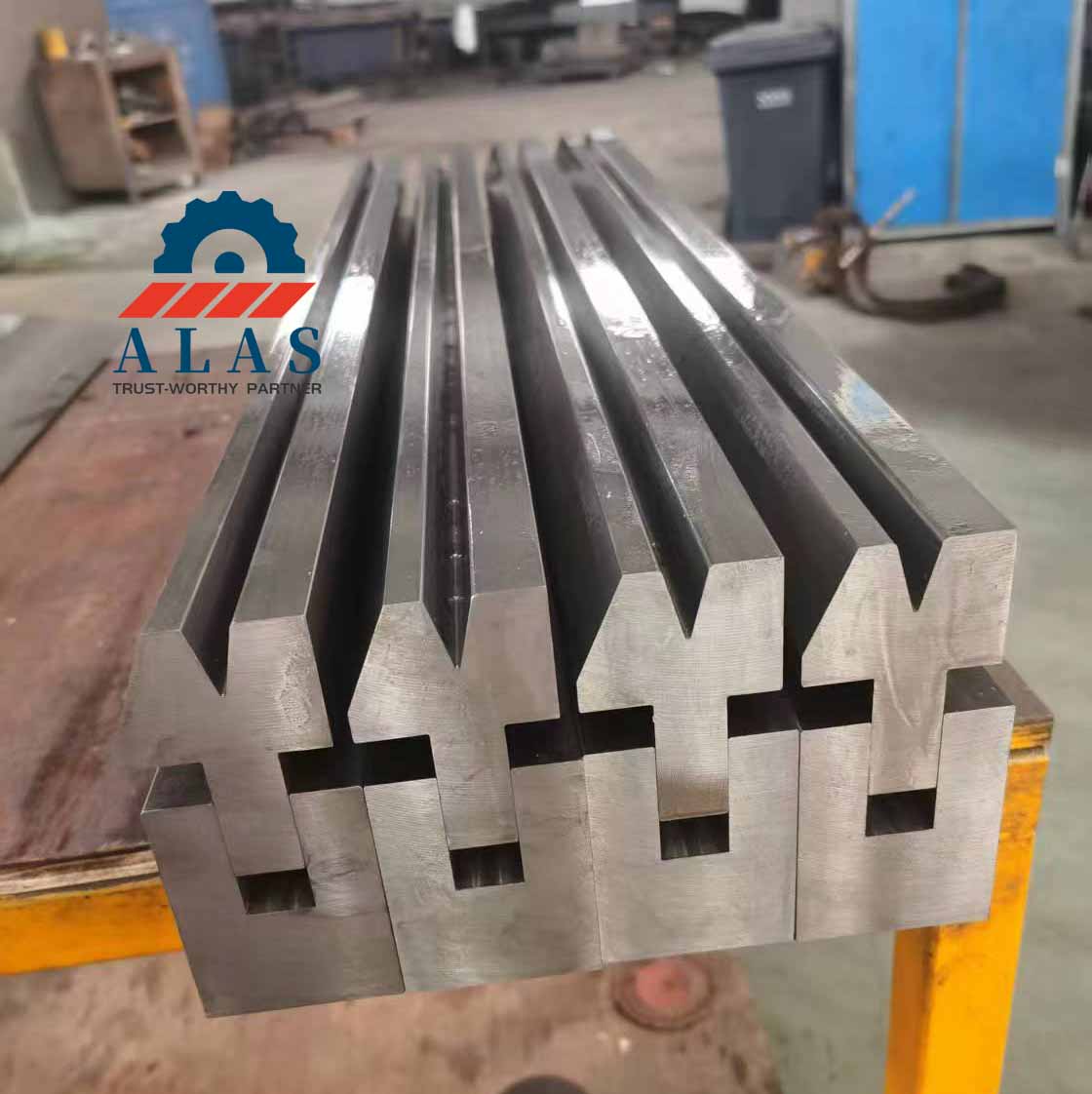 ALAS precision machined press brake hemming tools and compound flattening dies on a factory assembly table.