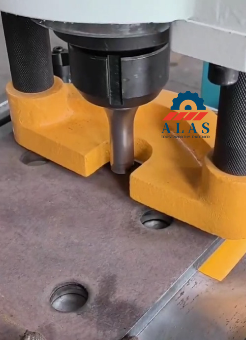 Hydraulic ironworker performing precision round hole punching on thick structural steel plate with ALAS punch and die