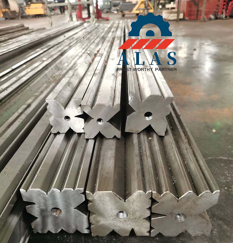 ALAS heavy duty 4-way press brake dies stack in factory, showing large X-shaped multi-V profile and center bores