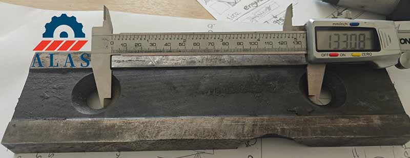 measuring center to center bolt hole pitch distance on worn industrial shear knife with digital caliper