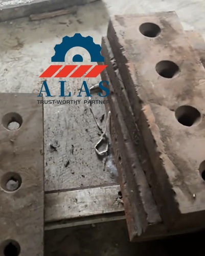 Heavily eroded and displaced segmented tool steel shear knife blocks on the workshop floor awaiting reverse engineering