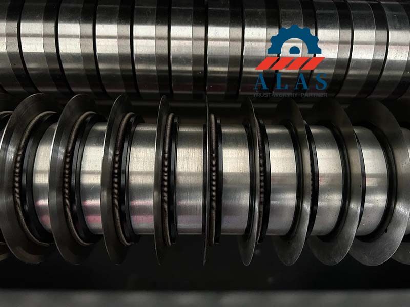 Precision top slitter knives and spacers aligned on an industrial paper converting machinery spindle arbor