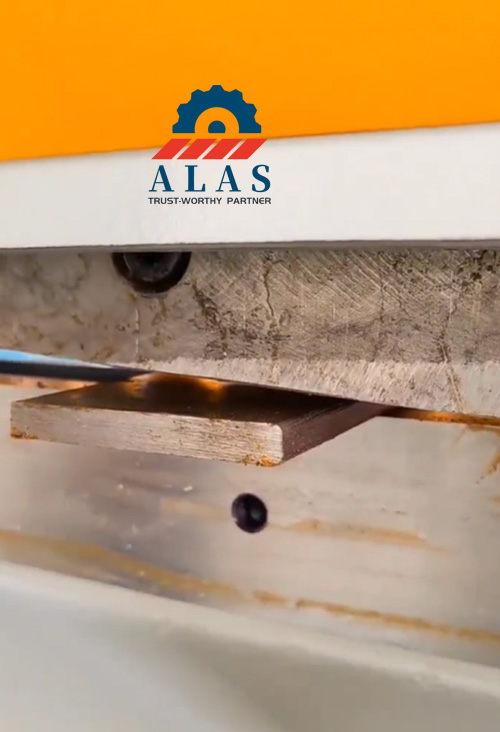 Close-up of a universal ironworker flat bar shear blade performing a clean cut on a metal plate