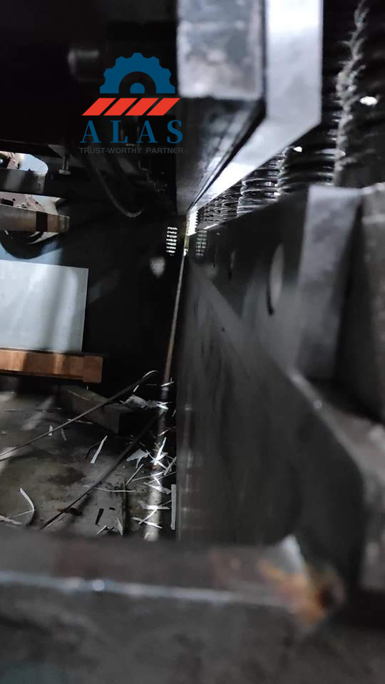 Close-up view of the single-sided gap calibration between the upper and lower blades on a hydraulic guillotine shear