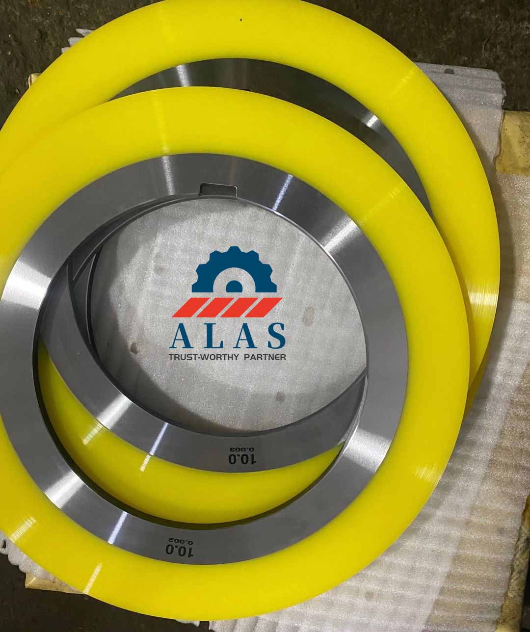 Polyurethane bonded stripper rings with laser-etched thickness markings designed to apply even stripping pressure on stainless steel strips.