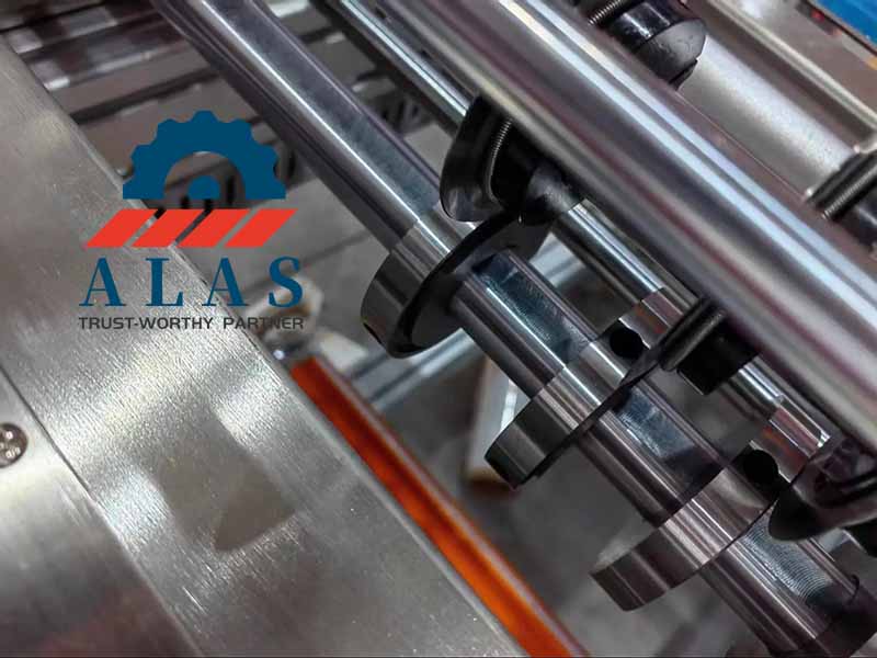 Close-up of circular slitter knives running synchronously on a tape rewinder machinery spindle arbor assembly.