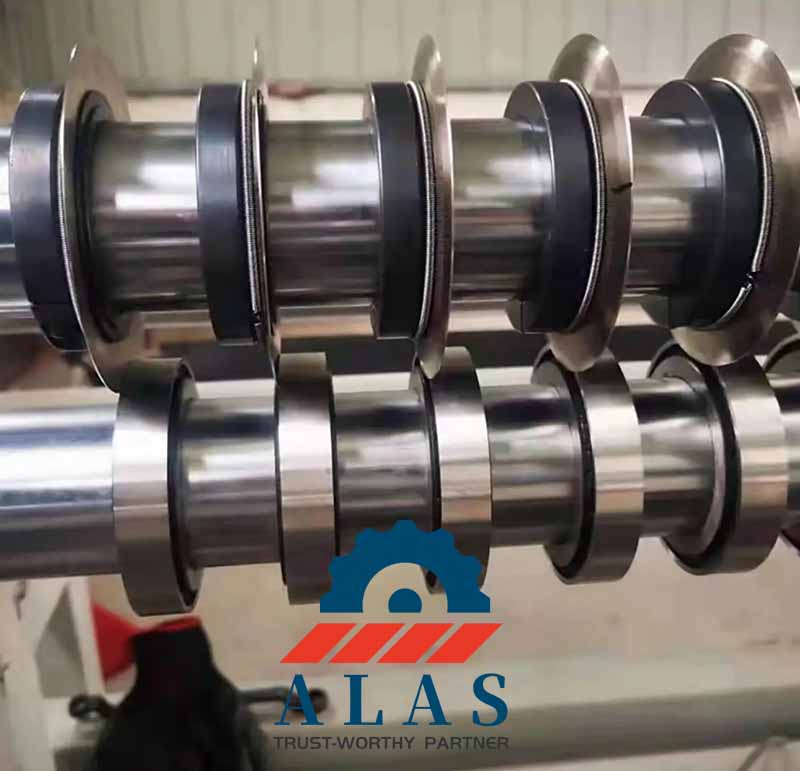 An industrial tape and film longitudinal slitting machine arbor assembled with multiple upper and lower synchronized rotary shear knives and spacers.