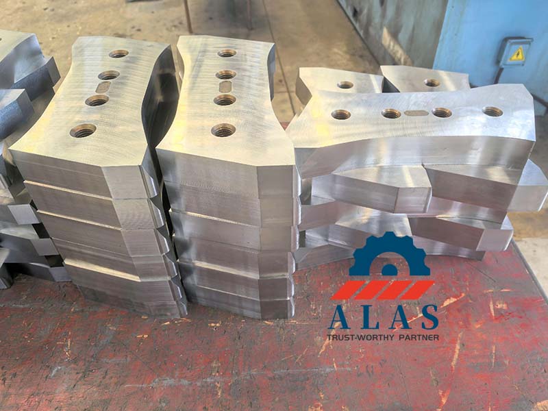 CNC precision ground excavator shear sabre teeth with bright metallic finish on workbench