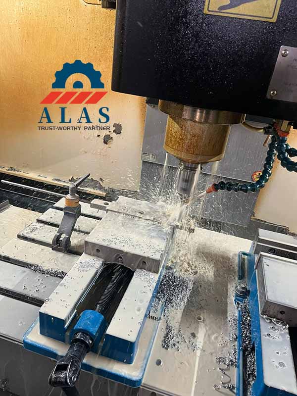 Automated multi-axis CNC machining center milling exact countersunk bolt hole coordinates onto a thick tool steel granulator blade under high-volume fluid coolant.