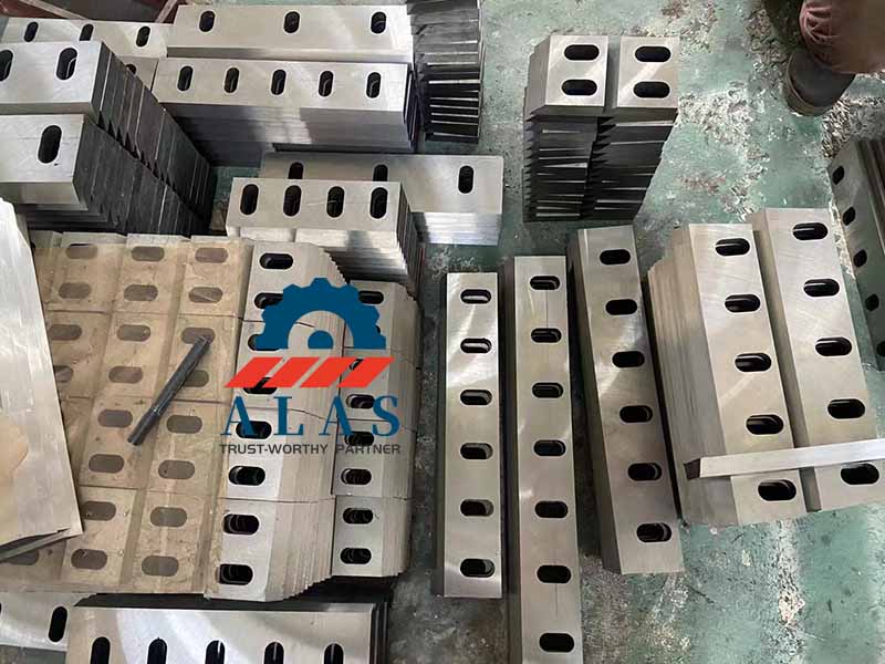 A massive wholesale batch inventory of precision-ground multi-slot SKD11 plastic crusher flat blades stacked at the ALAS factory workshop