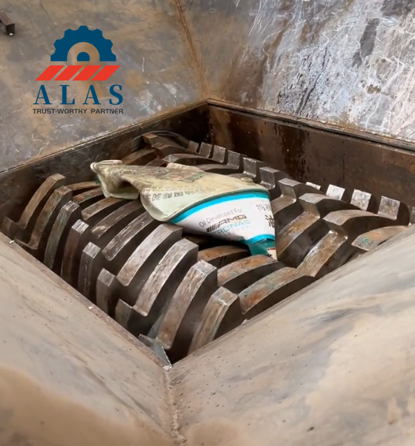 ALAS Metal Shredder Blades — Strong Hook-Tooth Grabbing & Shearing Performance Heavy-duty dual-shaft metal shredder blades shearing and crushing a scrap iron oil barrel in the cutting chamber