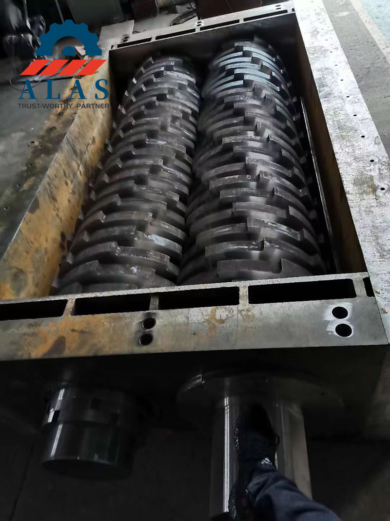 Inside view of a double shaft shredder chamber showing the heavy-duty cutting blades and interlocking rotors assembly